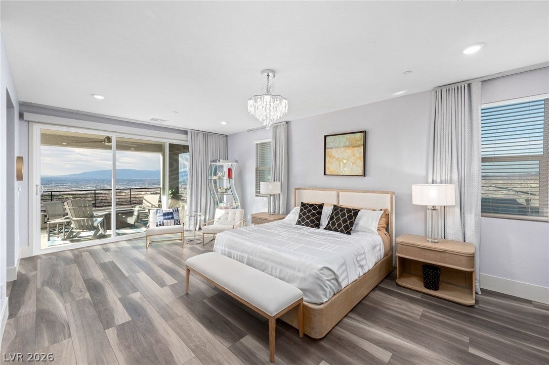 Gleaming wood floors and a glass sliding door framing far-reaching views enhance this bedroom.