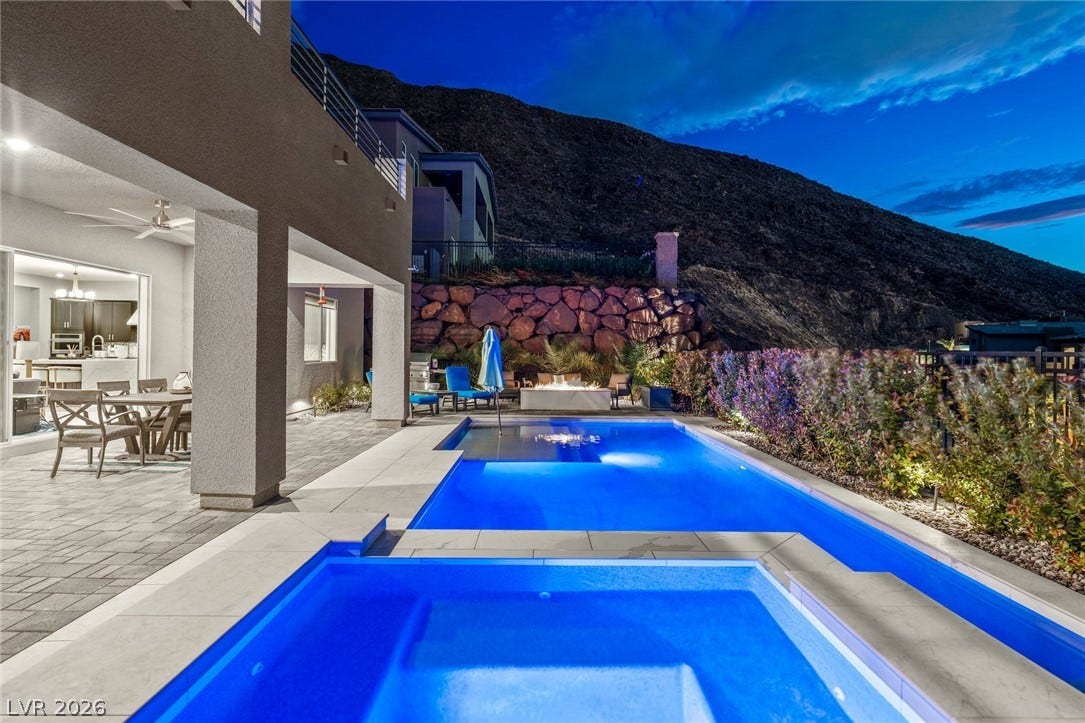 Dramatic mountain views provide a breathtaking backdrop for the geometric pool and patio.