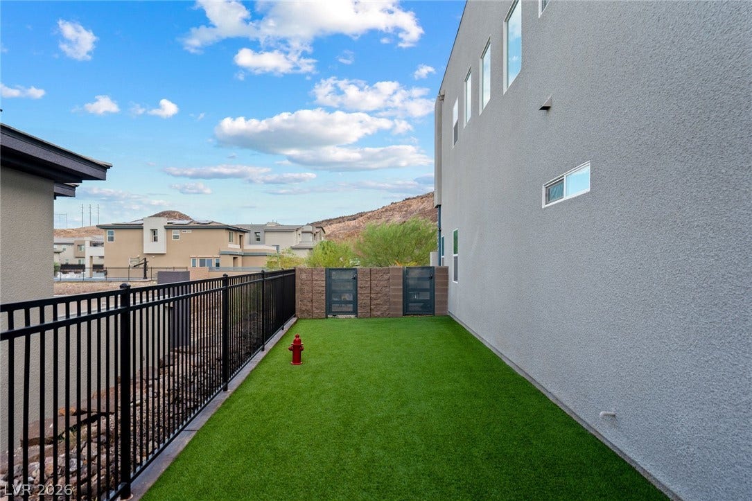 Clean lines and low-maintenance turf define this secure outdoor side yard space.
