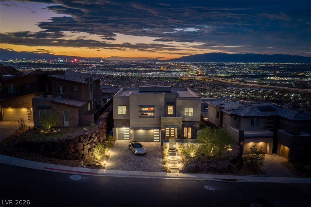 Breathtaking city lights and mountain views frame this modern architectural masterpiece at sunset.