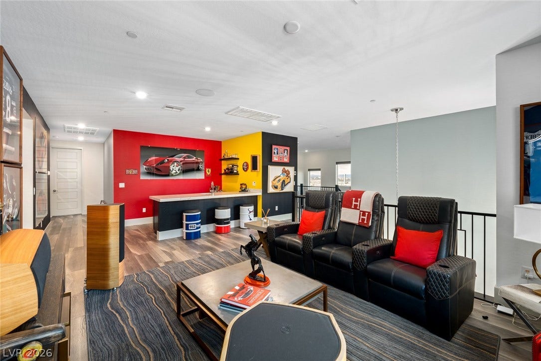 An open second-floor loft space features hardwood flooring and a built-in wet bar.