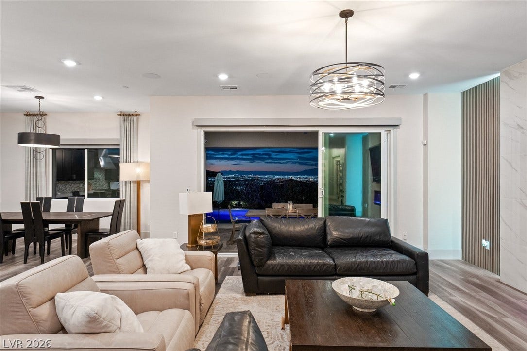 Sliding glass doors frame sweeping evening views from this modern open-concept living area.