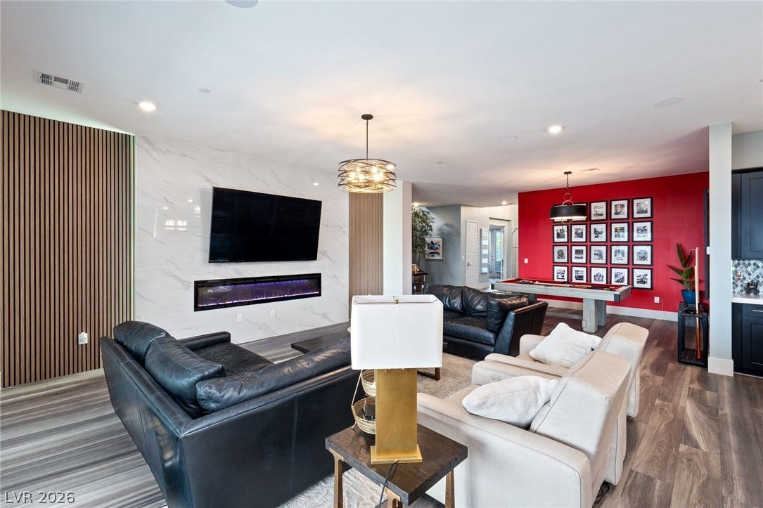 An open-concept living area anchors the home, boasting wide-plank flooring and a contemporary linear fireplace.