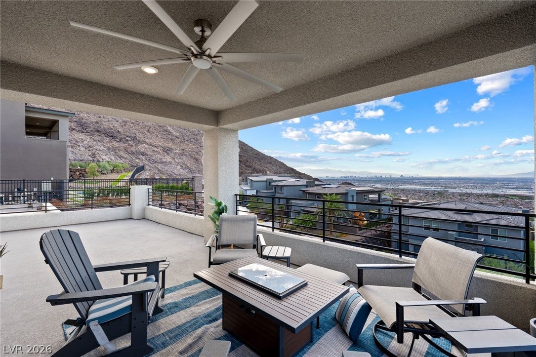 A spacious covered balcony provides sweeping elevated views of the valley and distant city skyline.