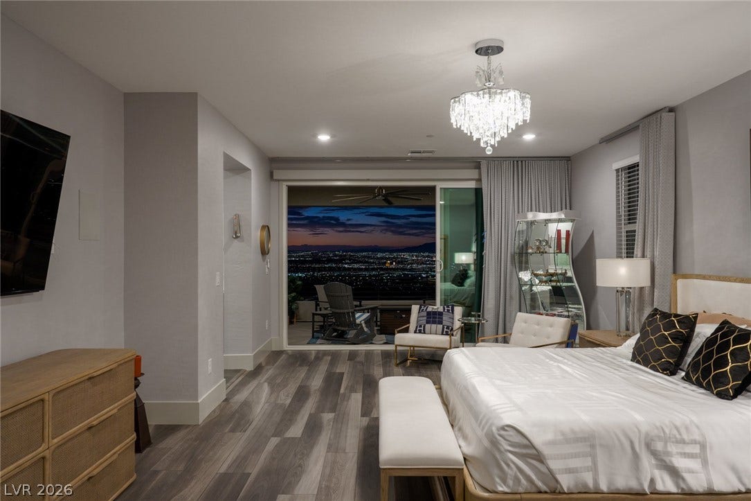 Sliding glass doors reveal glittering city light vistas from this main level retreat.