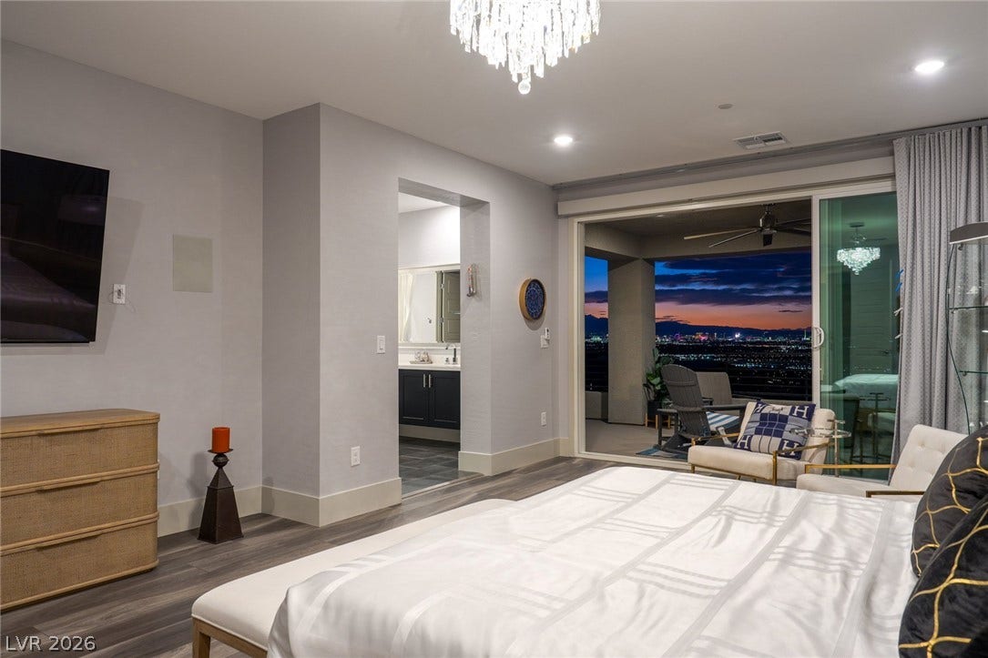 Sliding glass doors frame sweeping evening views from this tranquil bedroom retreat.