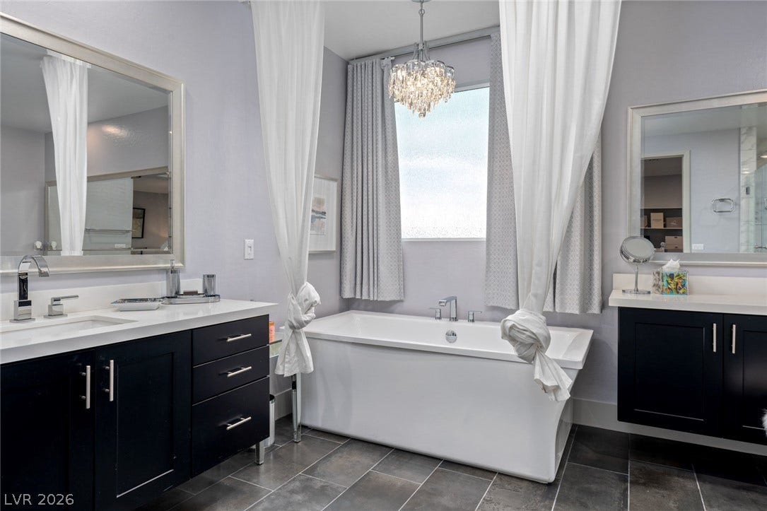 High ceilings and a deep soaking tub anchor this elegant, tiled bathroom space.