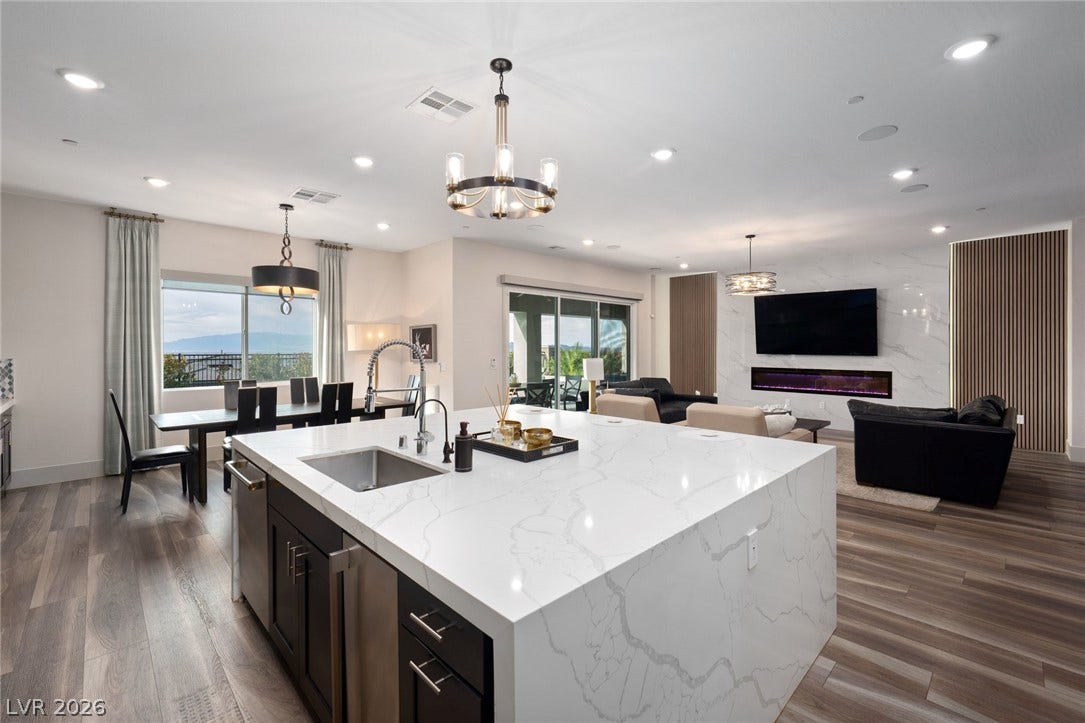 Clean lines and wide plank flooring define this expansive open concept kitchen and living area.