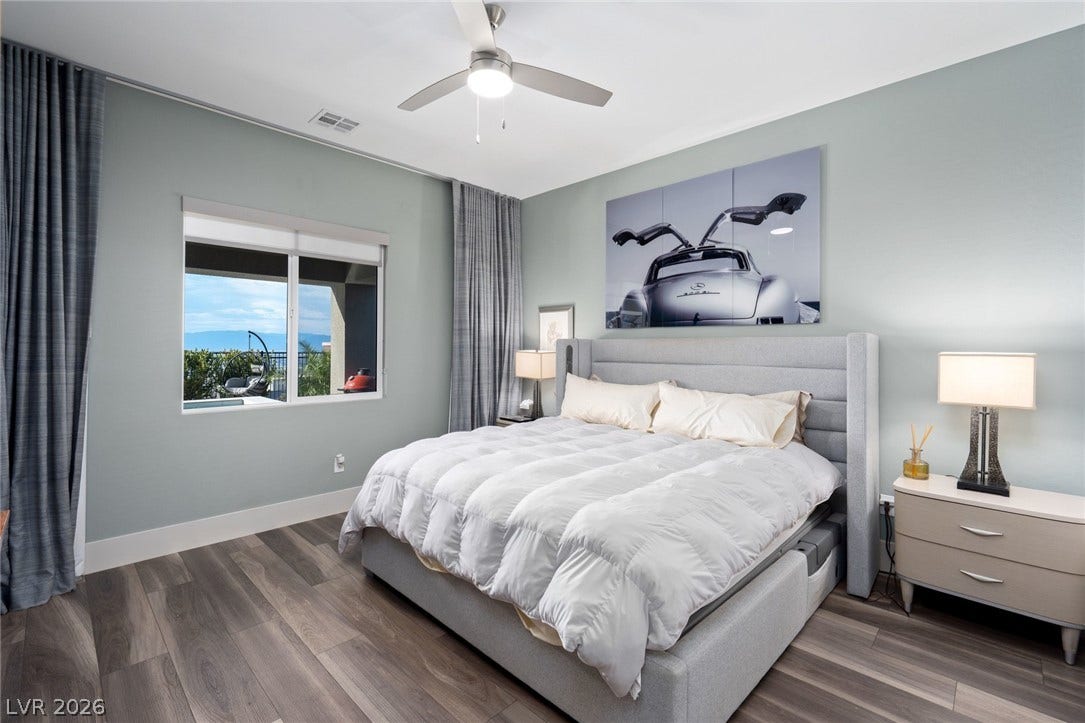 Gleaming hardwood floors and a wide window create an inviting secondary bedroom retreat.