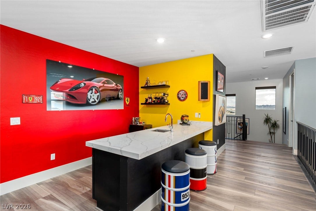 Smooth stone countertops and rich wood flooring define this open second-level bar area.