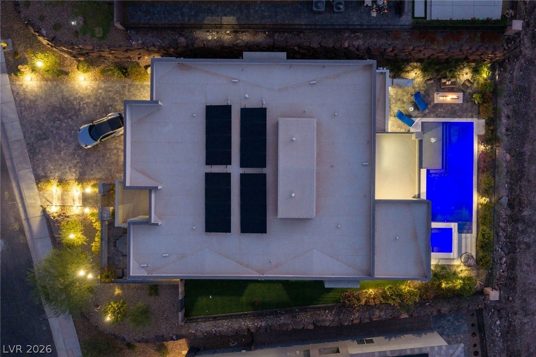 An aerial perspective reveals the architectural layout featuring a private swimming pool and integrated solar panels.