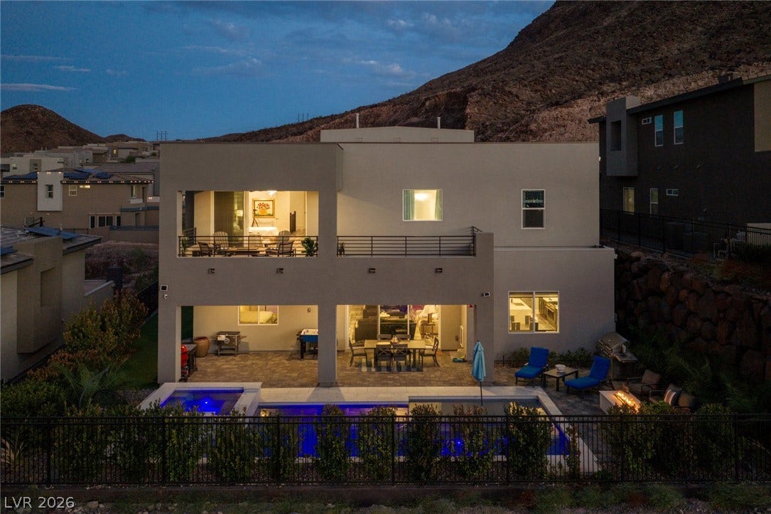 Dramatic mountain backdrops frame a modern multi-level backyard oasis with a pristine pool.