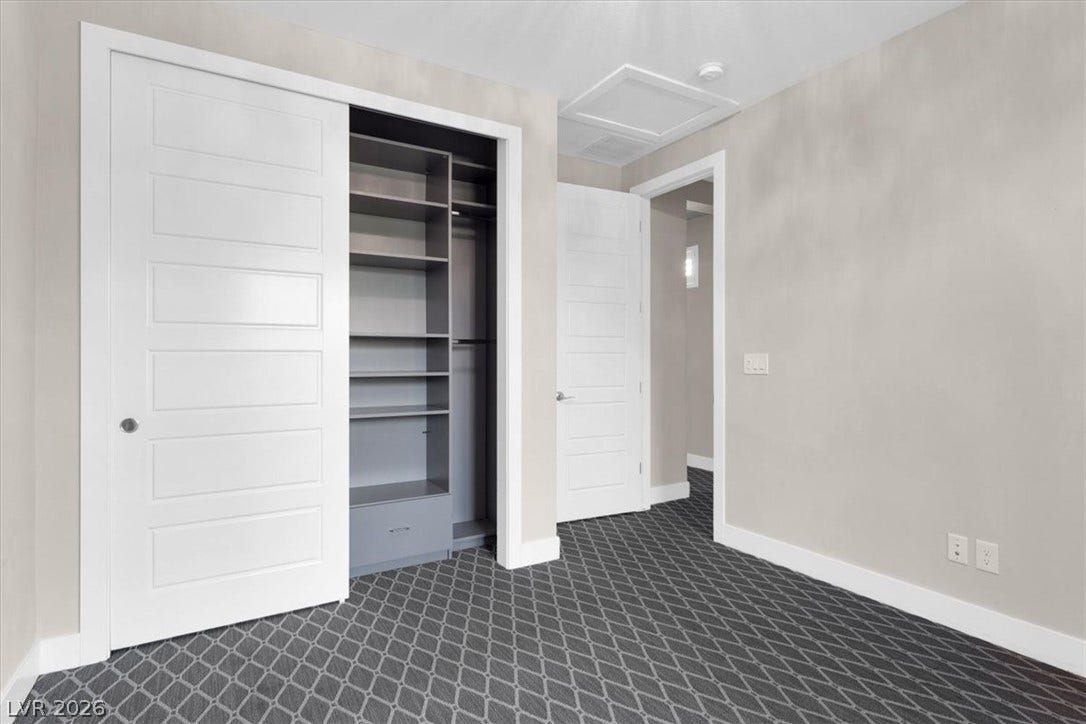 Second floor bedroom with attached bath, custom closets, and private balcony