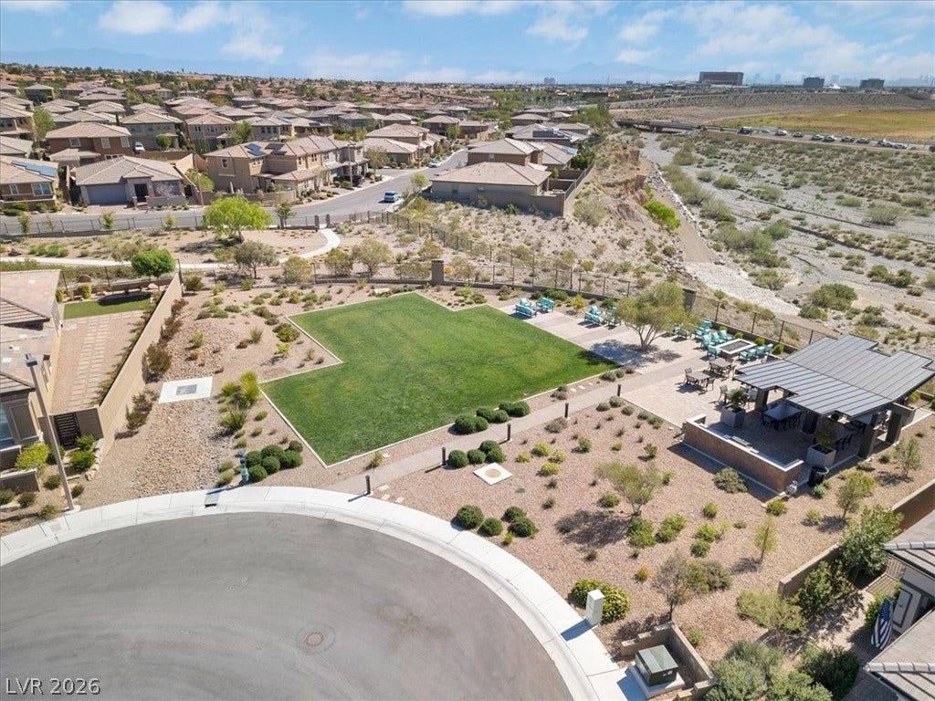 Aerial view of the community park featuring lush landscaping, covered areas and fire pit, with plenty of seating