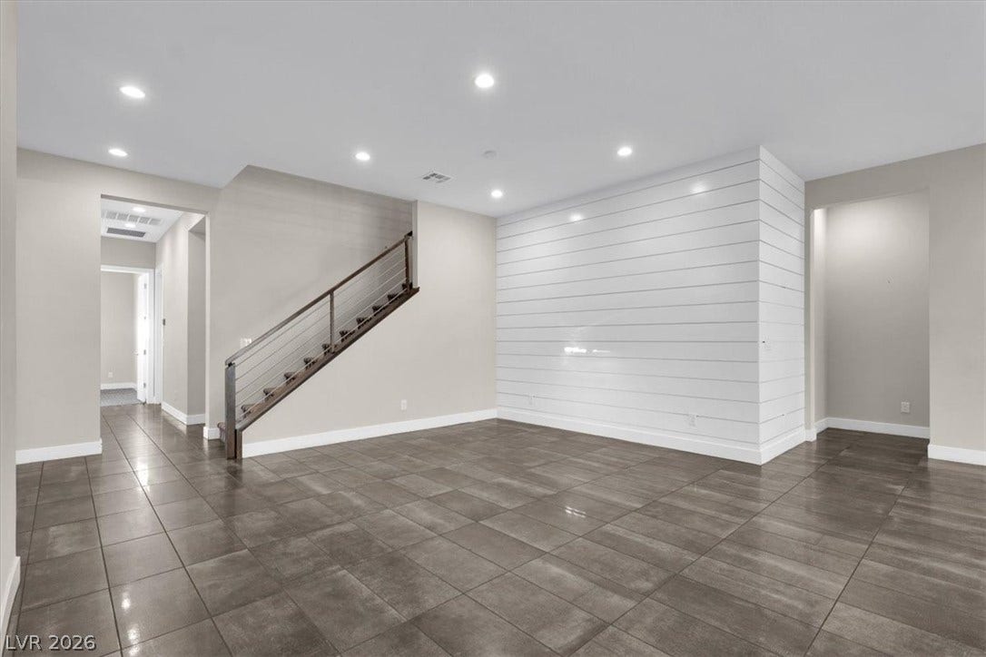 Dining room area featuring wood panelling, recessed lighting and dark tile patterned floors