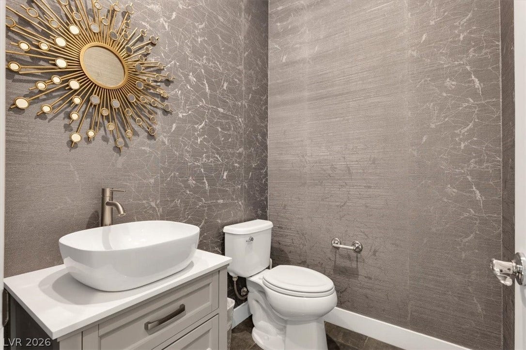 Guest powder room featuring vanity and custom wallpaper