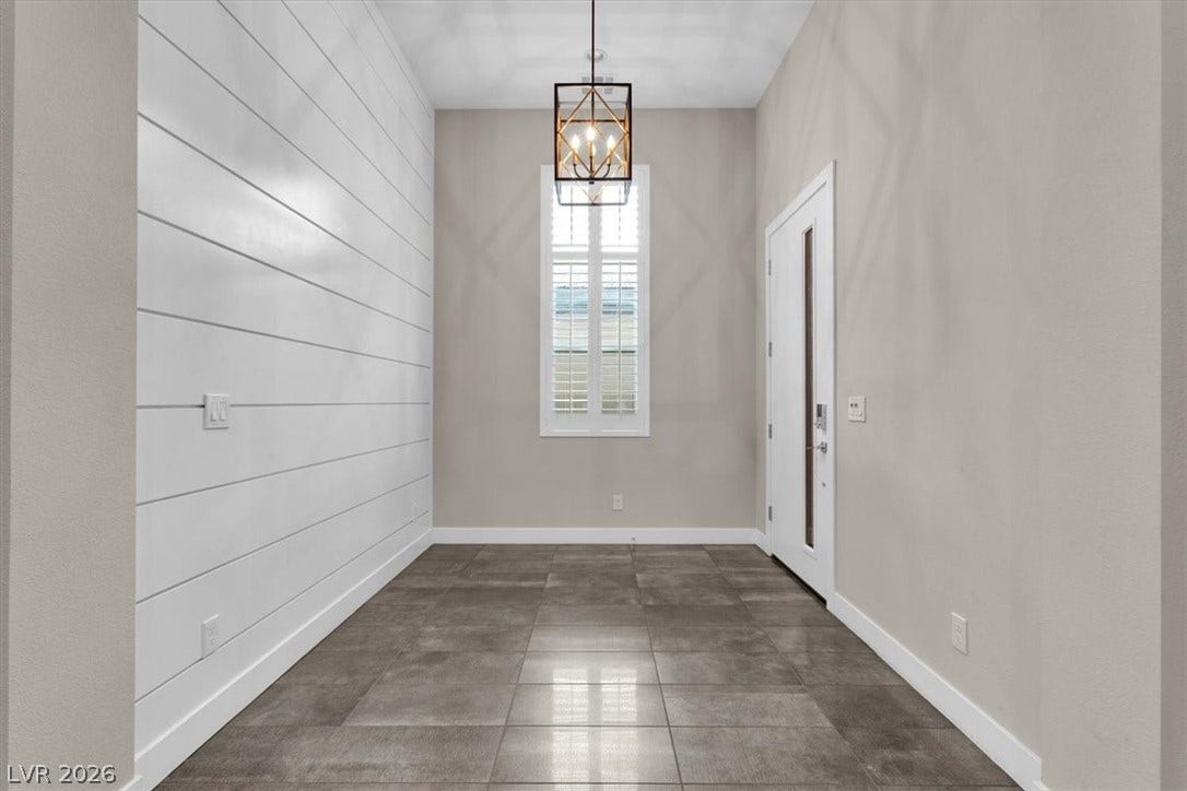 Entryway with wood panelling and premium lighting