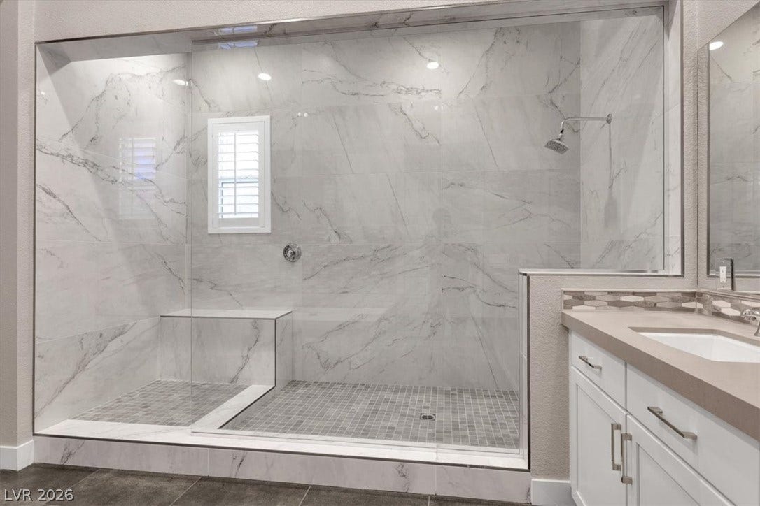 Full bath with a premium finish shower, large vanity, and a soaking tub