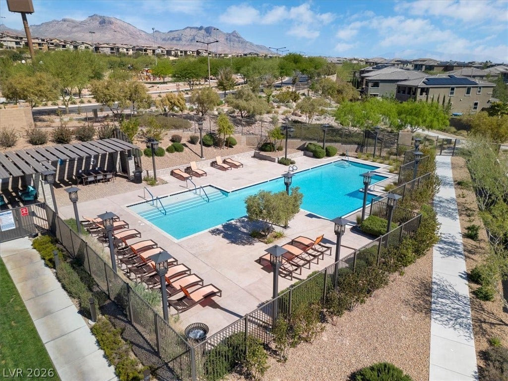 Community pool featuring a pergola, loungers, and a patio area