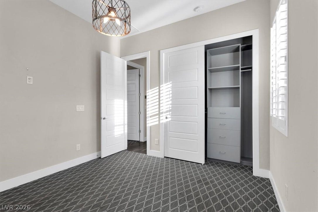 Third downstairs bedroom featuring custom lights, plush carpet, and custom closet