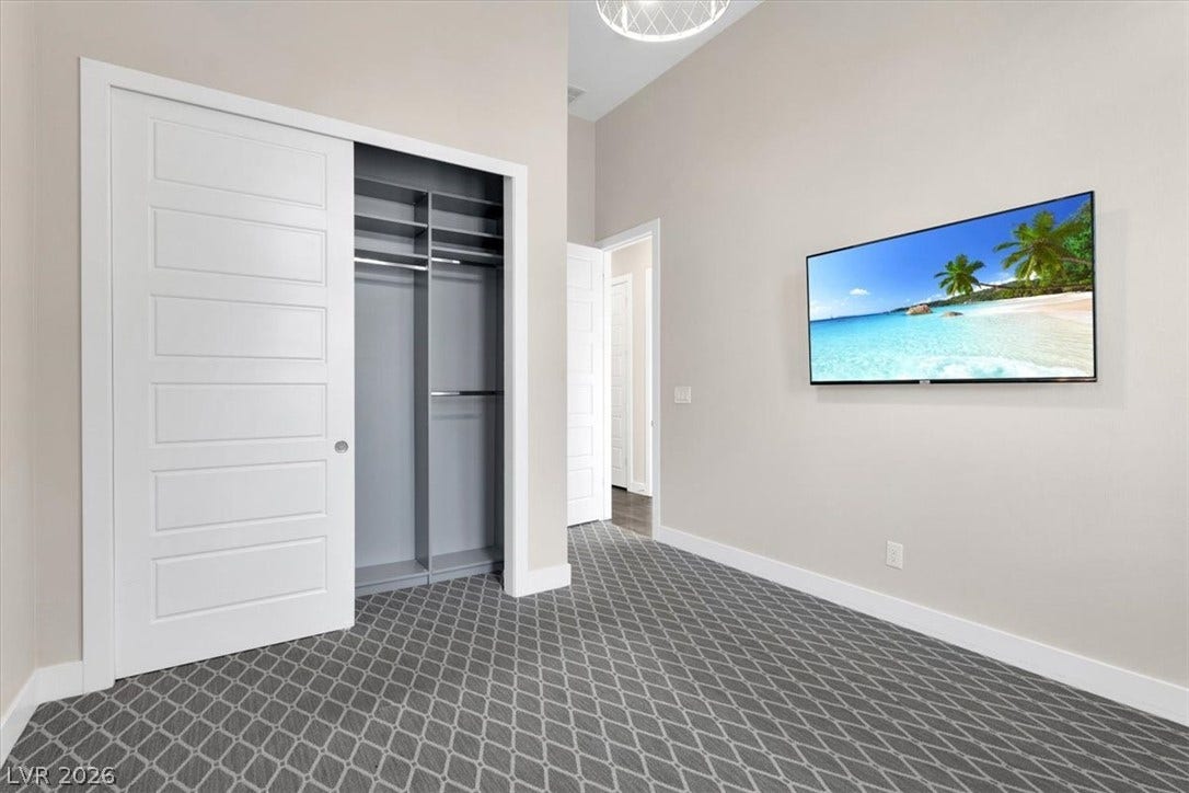 Downstairs bedroom featuring custom lights, plush carpet, and custom closet