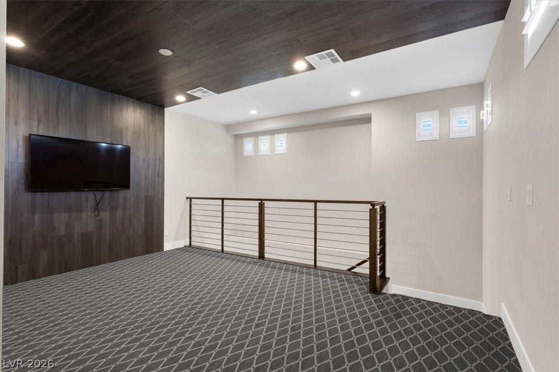 Second floor loft perfect for movie nights featuring plush carpet, recessed lighting, and wooden ceiling accents