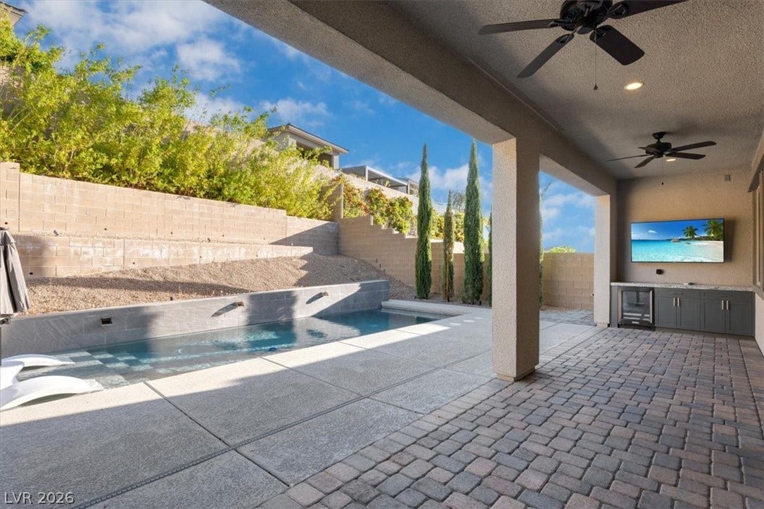 Outdoor pool with a patio, a fenced backyard, drybar with fridge and TV perfect for entertaining