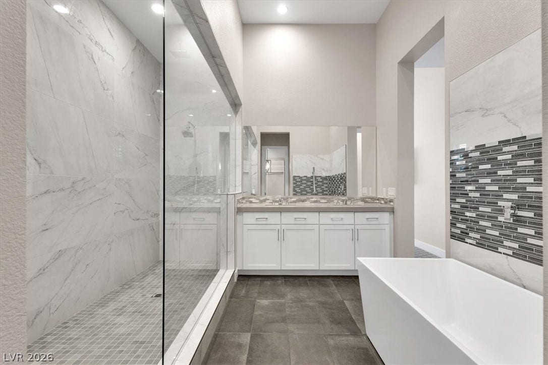 Full bath with a premium finish shower, large vanity, and a soaking tub