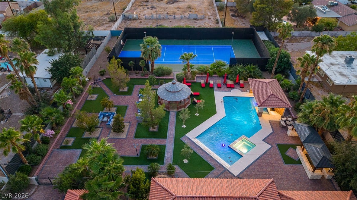1355 Westwind Road, Las Vegas, NV 89146 An aerial perspective showcases an expansive backyard retreat featuring a pool, spa, and tennis court.