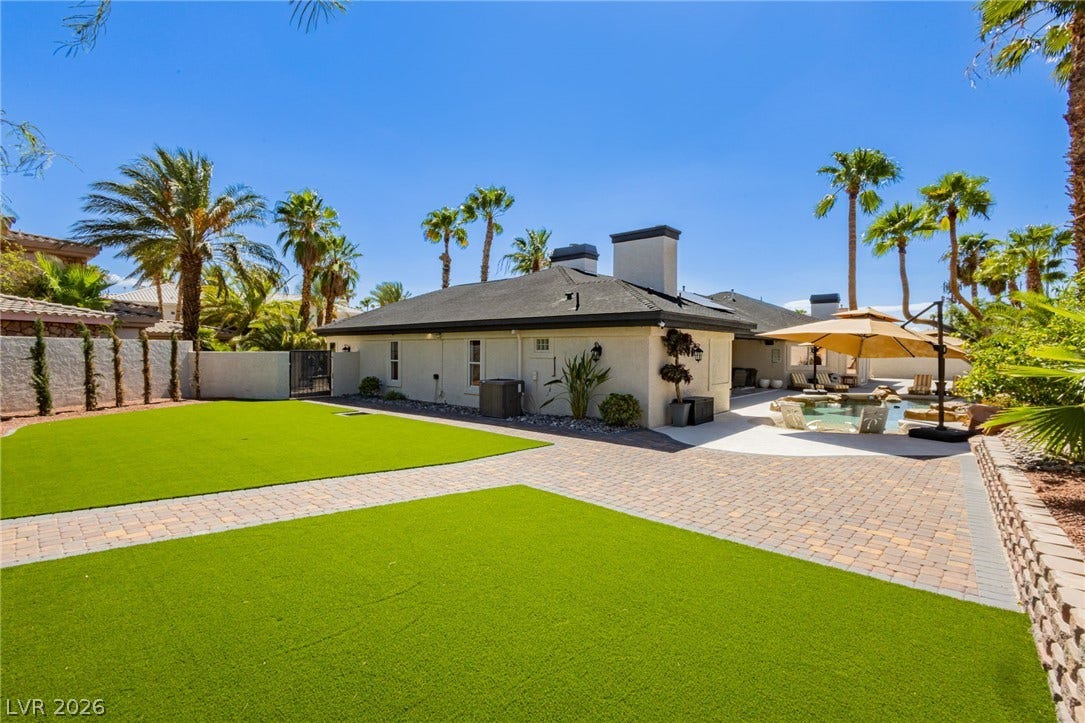 Manicured lawns and paver pathways frame the inviting rear exterior of this desert retreat.