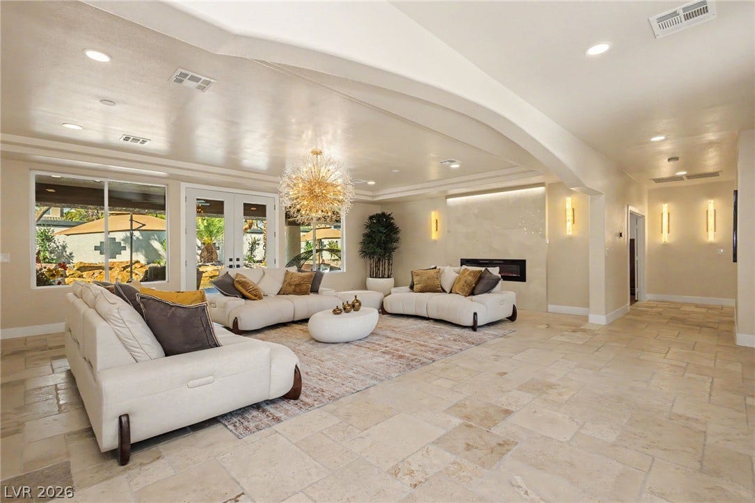 Gleaming tile floors and architectural arches define this airy, open-concept living space.