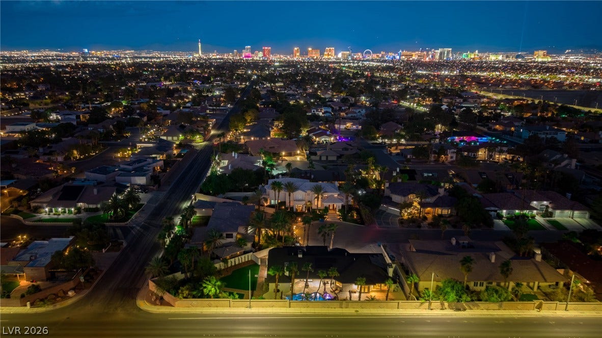 Glittering city skyline lights provide a spectacular backdrop to this expansive residential neighborhood.