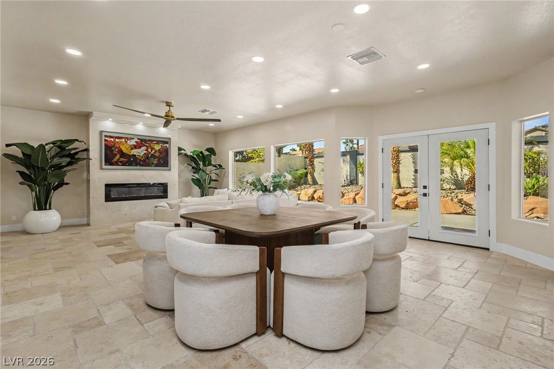 Stone tile flooring and recessed lighting accent this open dining area overlooking the patio.