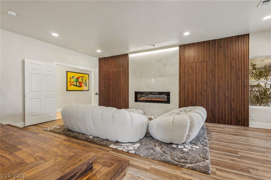 Rich wood flooring and a modern fireplace elevate this inviting living space.