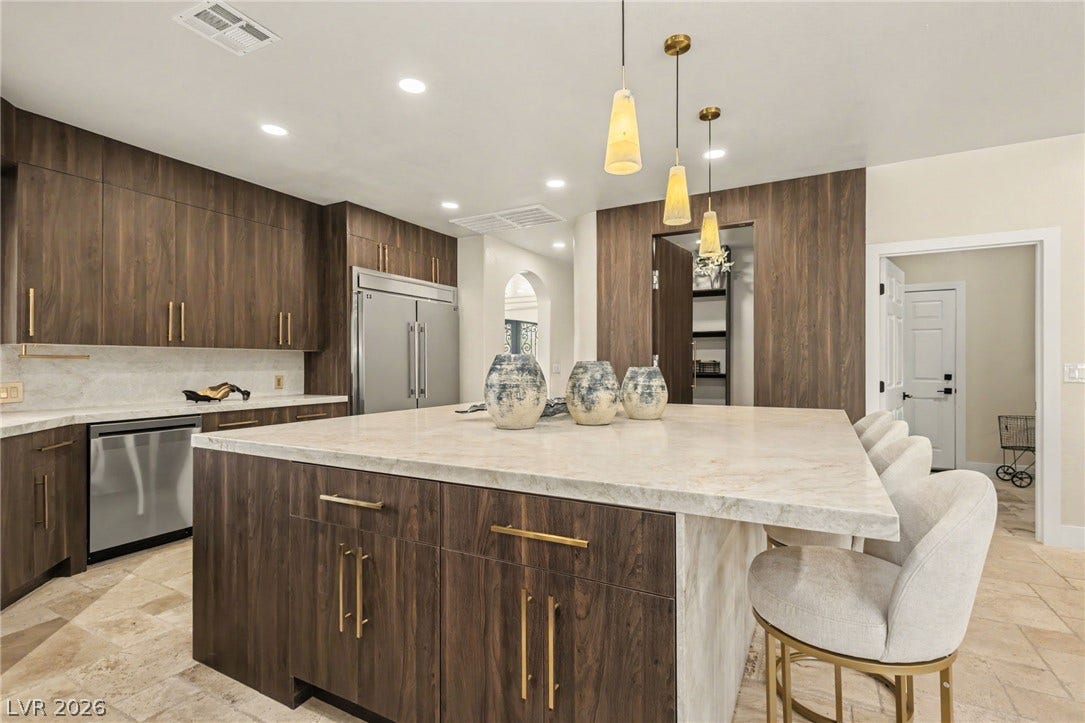 Gleaming stone countertops and rich wood cabinetry define this central culinary gathering space.