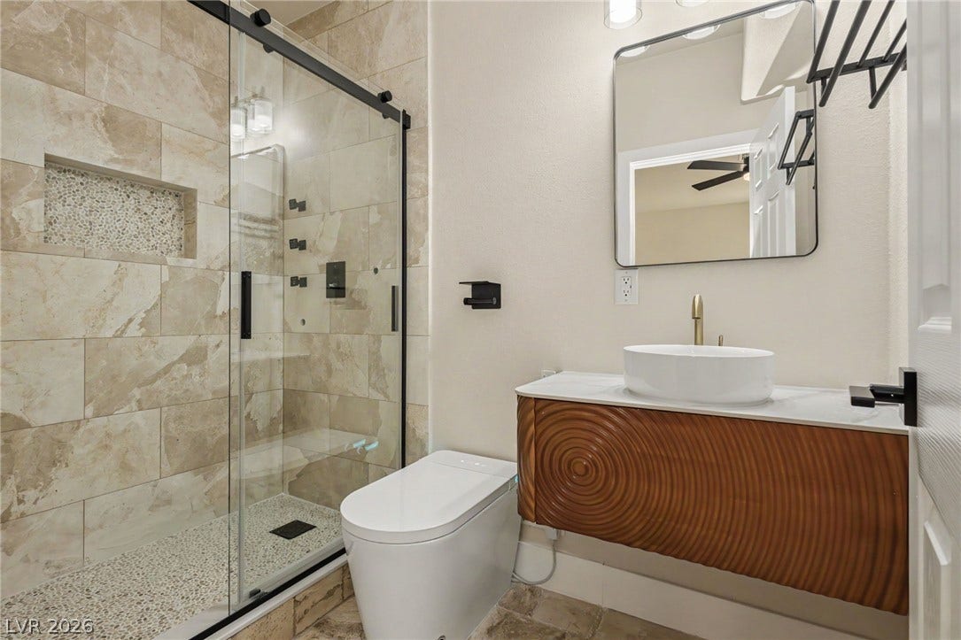Stone tiling pairs with a floating vanity in this contemporary bathroom setup.