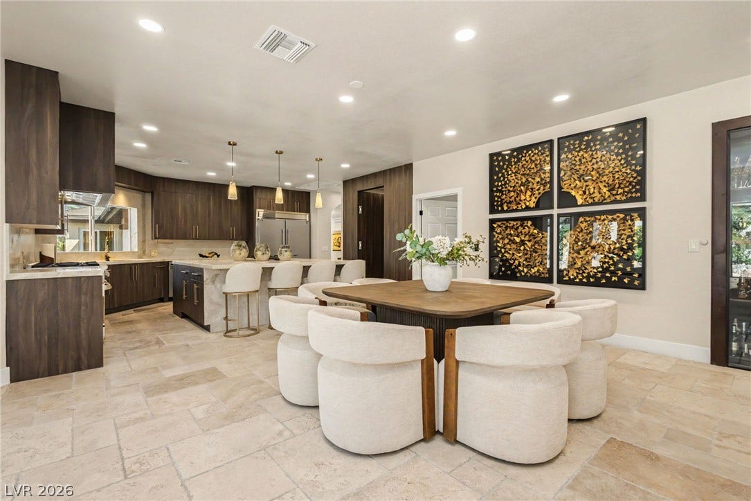 Gleaming stone tile flooring sweeps through this open dining area adjacent to the kitchen.