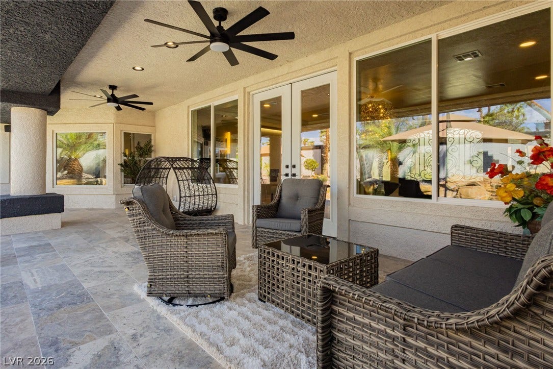 An inviting covered patio features durable tiled flooring and elegant French doors.