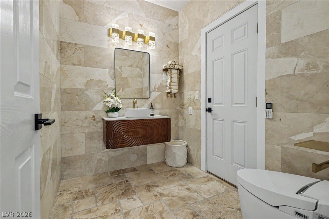 Floor-to-ceiling tiling and a floating vanity create a refined contemporary aesthetic in this bathroom.
