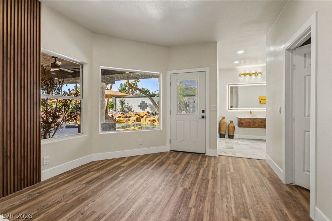 Rich wood-look flooring and clean architectural lines define this welcoming entryway.