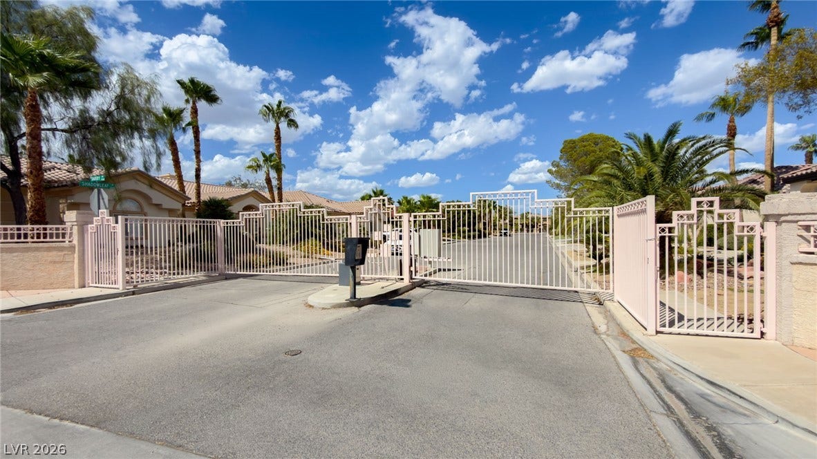 Secure gated entry introduces this neighborhood of homes framed by palm trees.