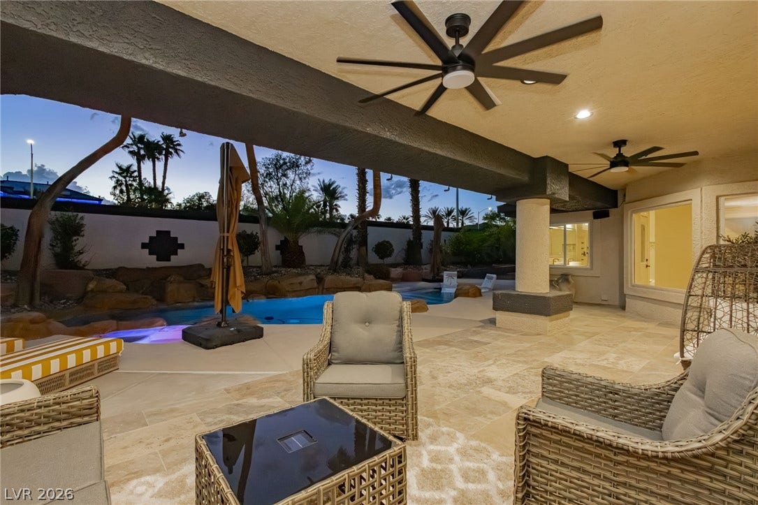 Tiled flooring extends across a covered patio that overlooks the swimming pool.