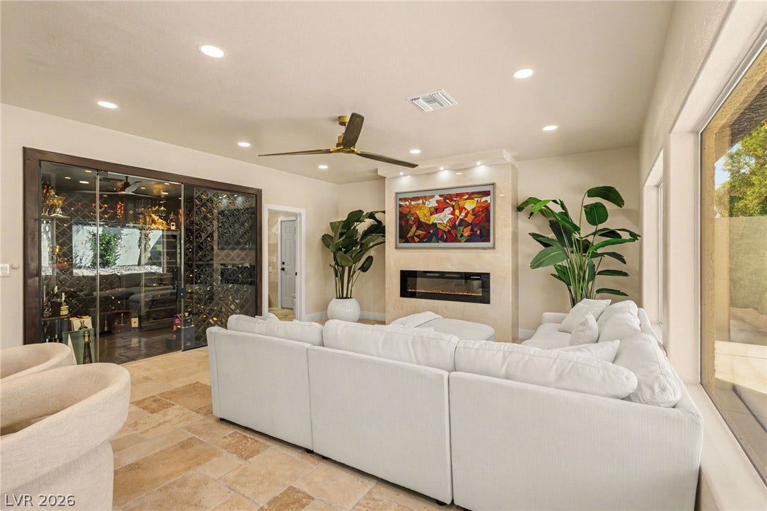 Sleek modern lines define this warm living area complete with a walk-in glass wine display.