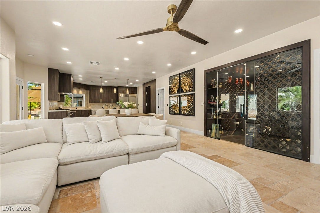 An open floor plan connects the living spaces over polished stone flooring.