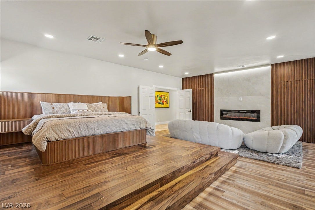 Rich wood floors and a contemporary fireplace define this luxurious bedroom suite.