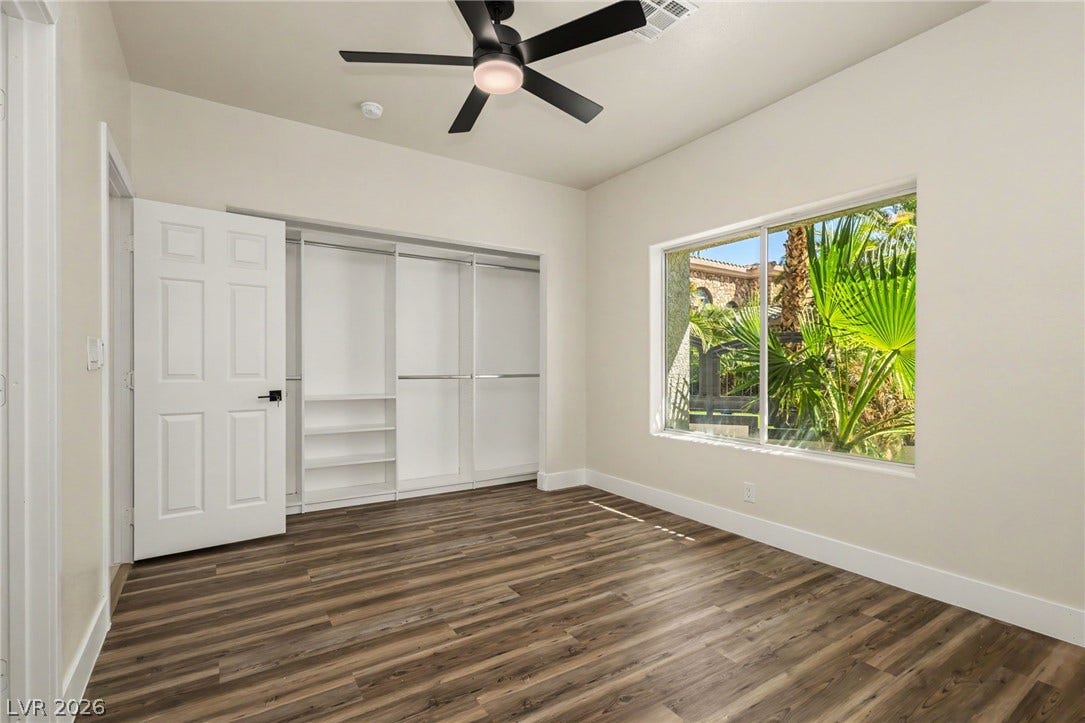 Rich wood-inspired flooring and a wide window frame lush garden views in this versatile space.