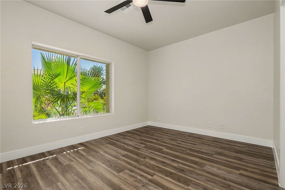 Gleaming wood flooring and a large picture window accent this versatile bedroom space.