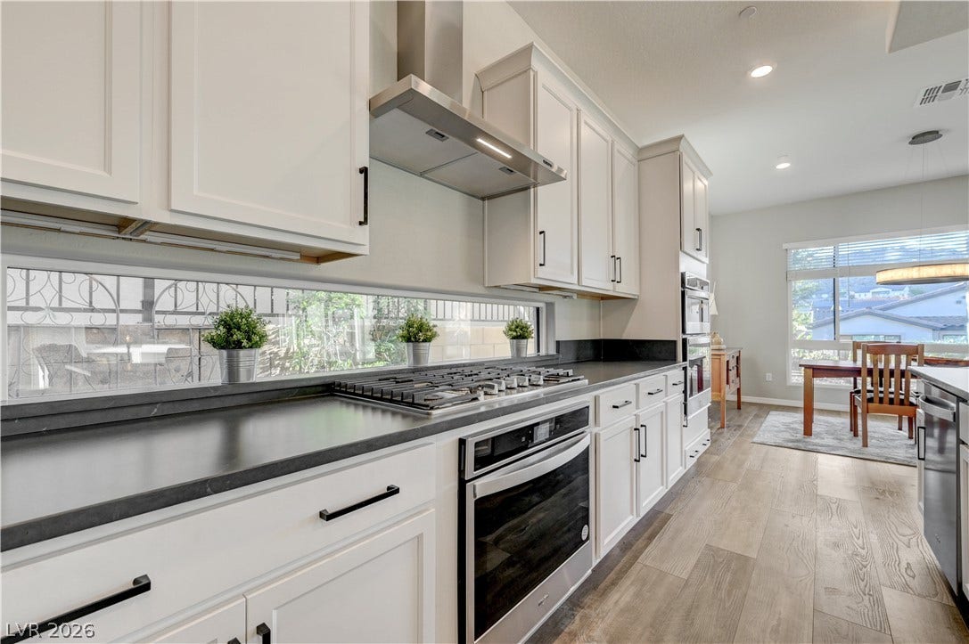 51 Thorn Creek Street, Henderson, NV 89011 Kitchen with recessed lighting, white cabinets, light wood-type flooring, stainless steel appliances, and dark stone countertops