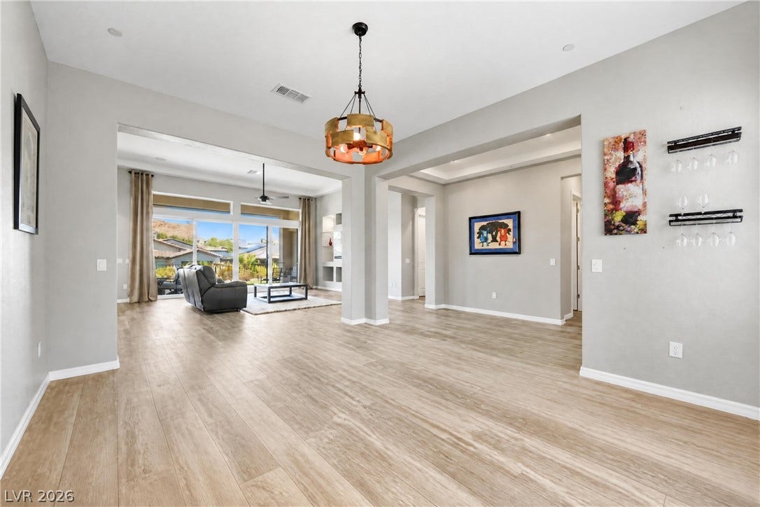 51 Thorn Creek Street, Henderson, NV 89011 An open floorplan flows seamlessly over wood-look flooring beneath high ceilings.