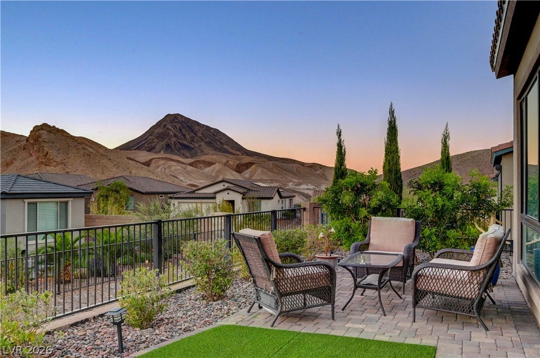 51 Thorn Creek Street, Henderson, NV 89011 Patio terrace at dusk with a patio area, a fenced backyard, a mountain view, and an outdoor lounge area